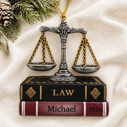 Personalized legal scales of justice christmas ornament laid on a soft white knit blanket