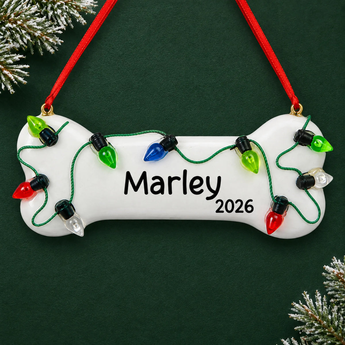 Personalized Christmas Lights Dog Bone ornament on a dark green pine background