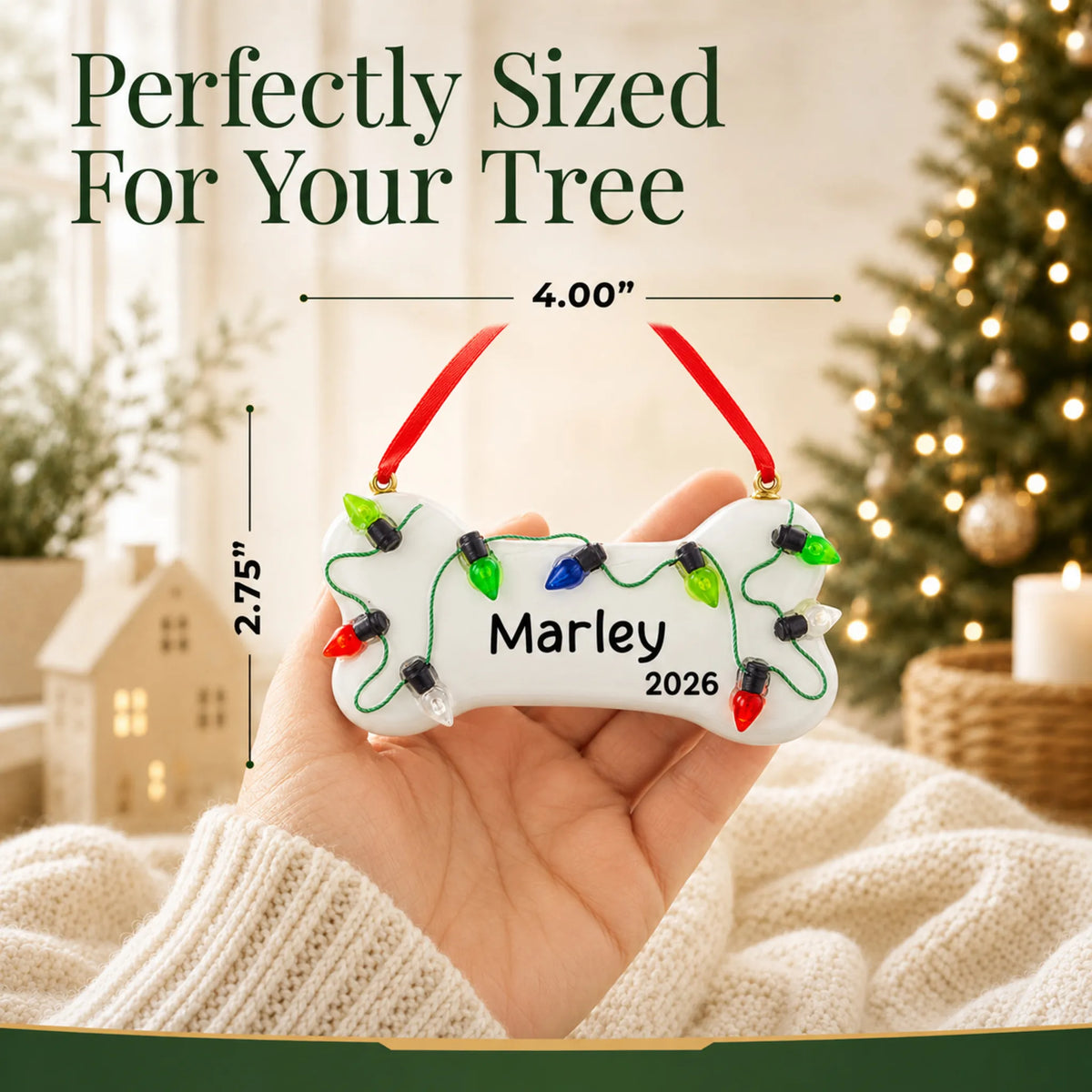 Size guide: the personalized Christmas Lights Dog Bone ornament is 4.00 in wide by 2.75 in tall, shown in hand