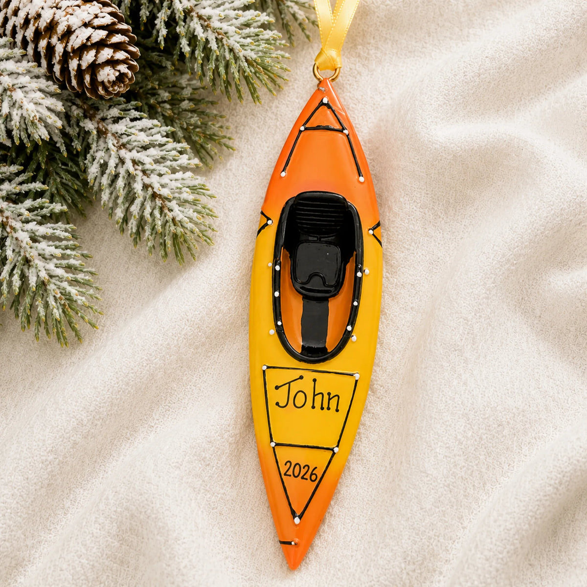 Personalized 3D kayak christmas ornament laid on a soft white knit blanket
