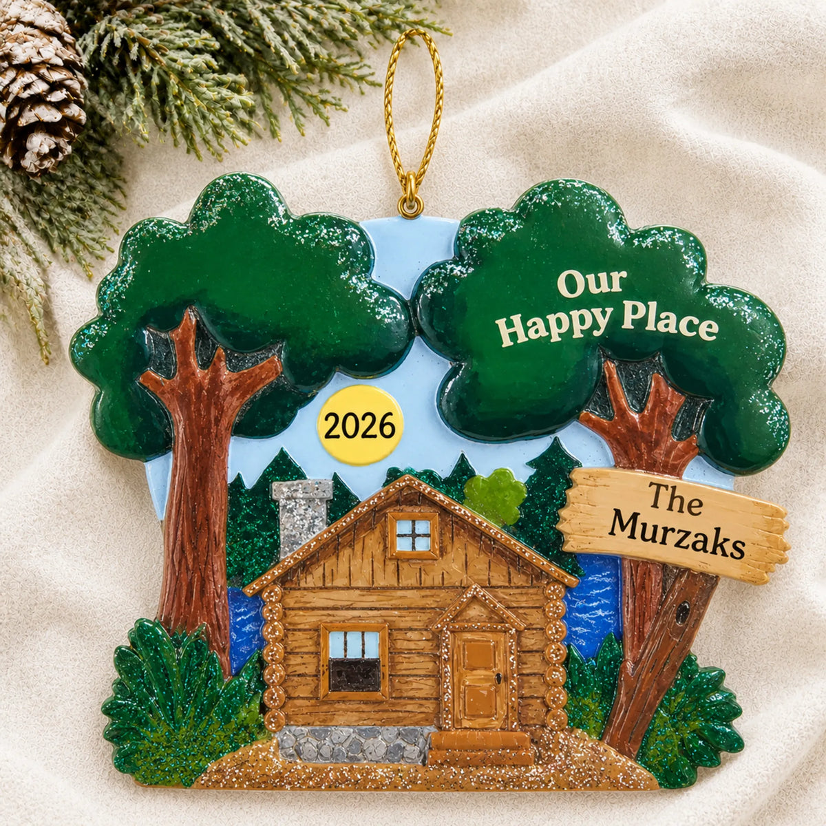 Personalized lake cabin christmas ornament laid on a soft white knit blanket
