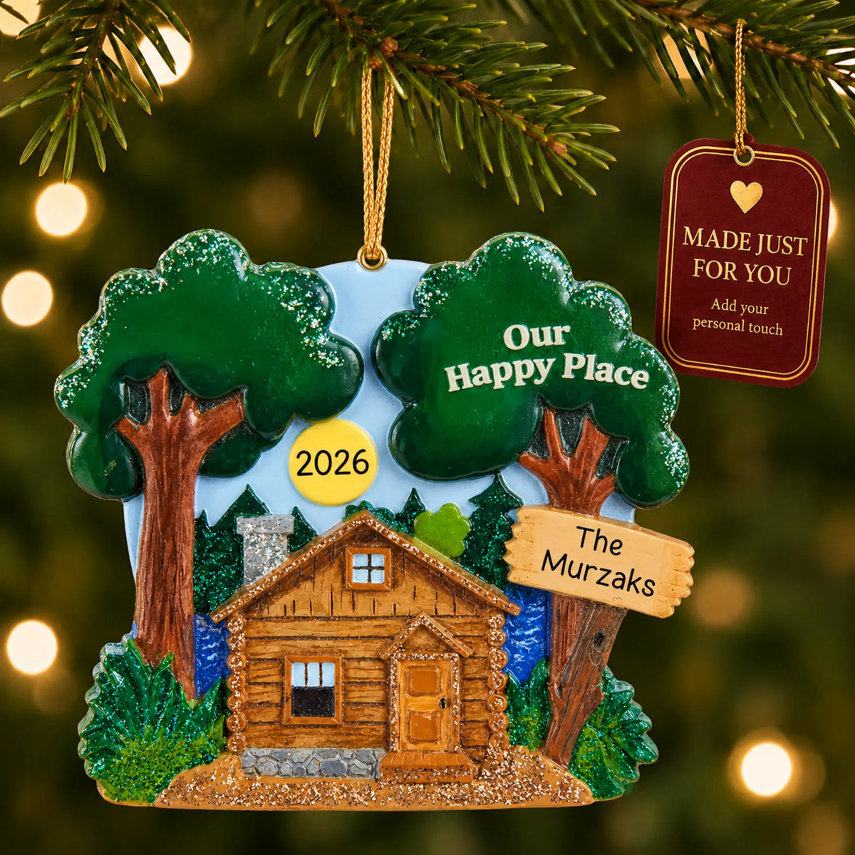 Lake cabin christmas ornament hanging on a lit Christmas tree with a Made Just For You gift tag