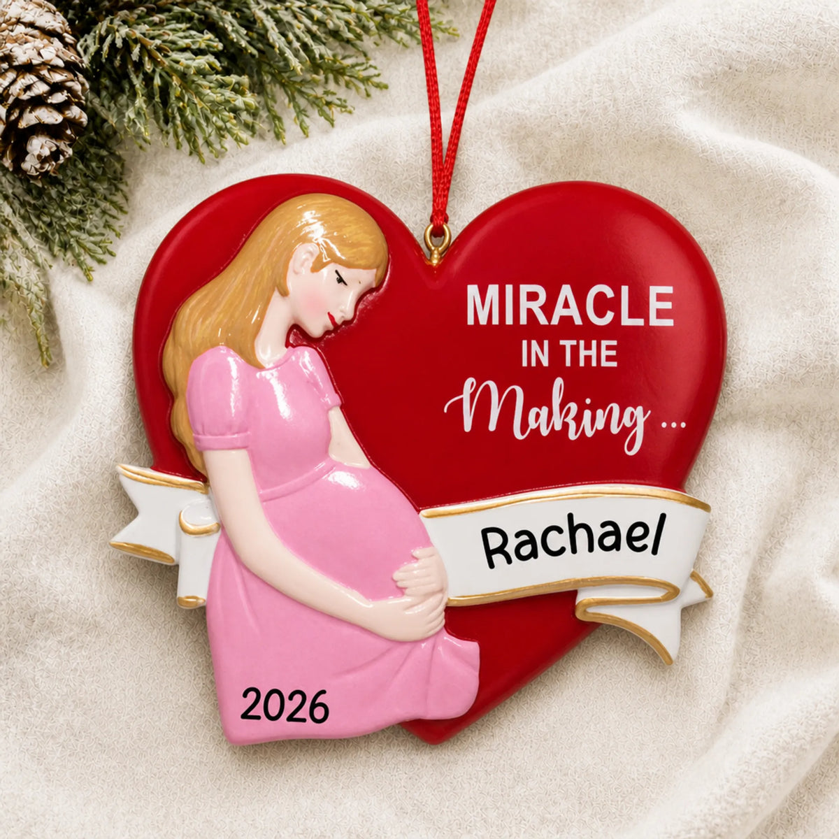 Personalized Expecting Mom christmas ornament laid on a soft white knit blanket