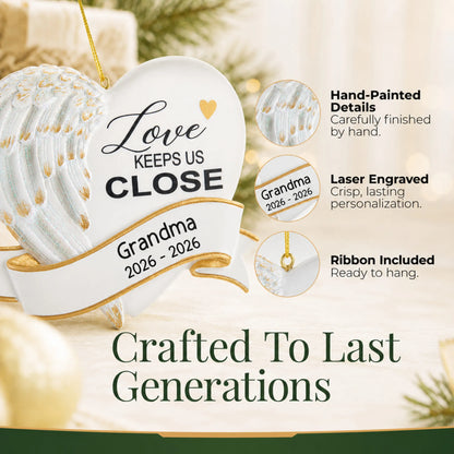 Hand-painted details and laser engraved personalization on the Love Keeps Us Close christmas ornament, ribbon included