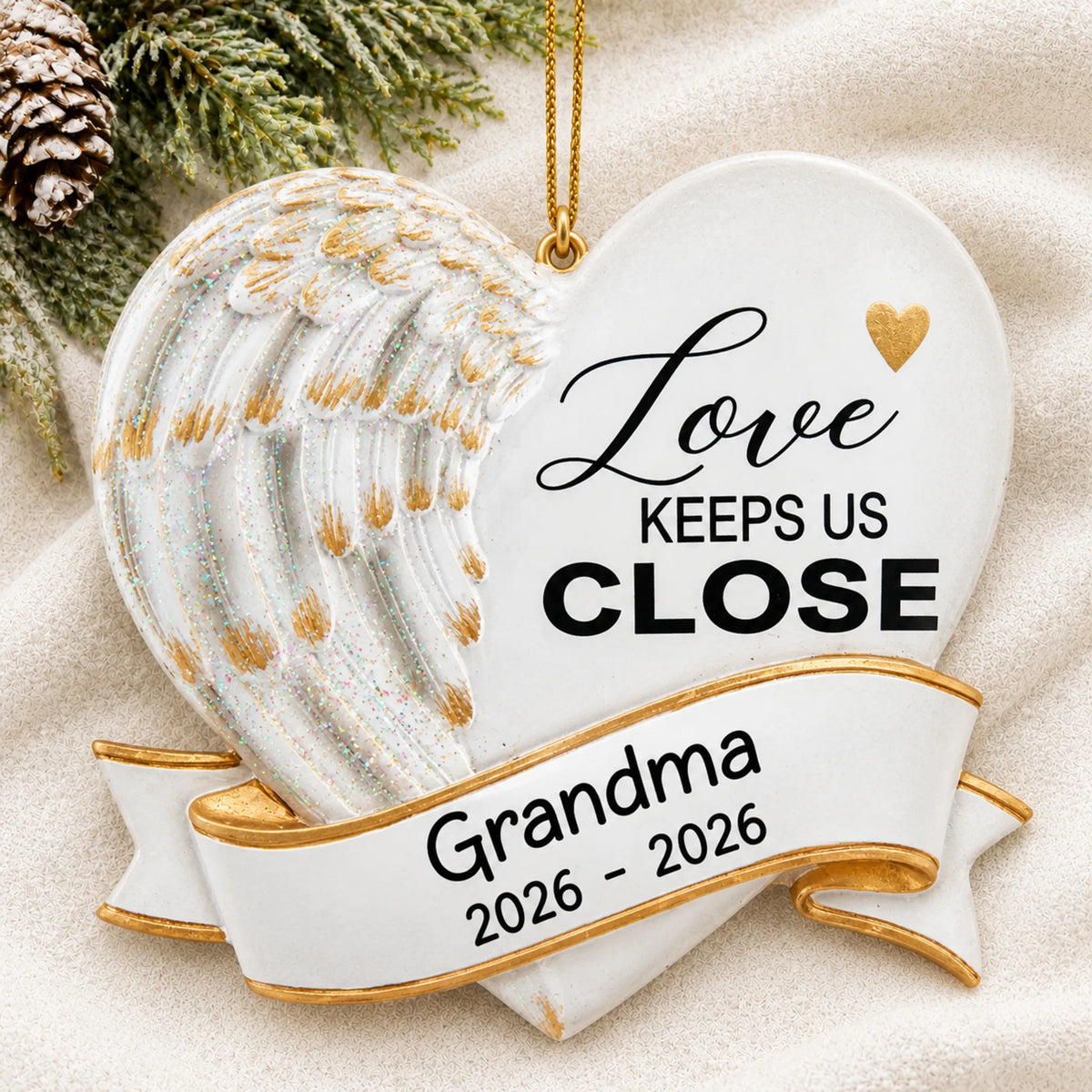 Personalized Love Keeps Us Close christmas ornament laid on a soft white knit blanket