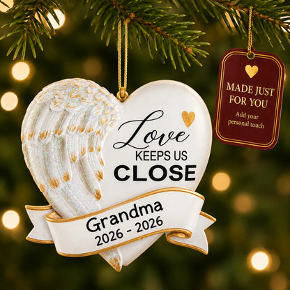 Love Keeps Us Close christmas ornament hanging on a lit Christmas tree with a Made Just For You gift tag