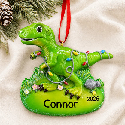 Personalized christmas lights t-rex dinosaur ornament laid on a soft white knit blanket