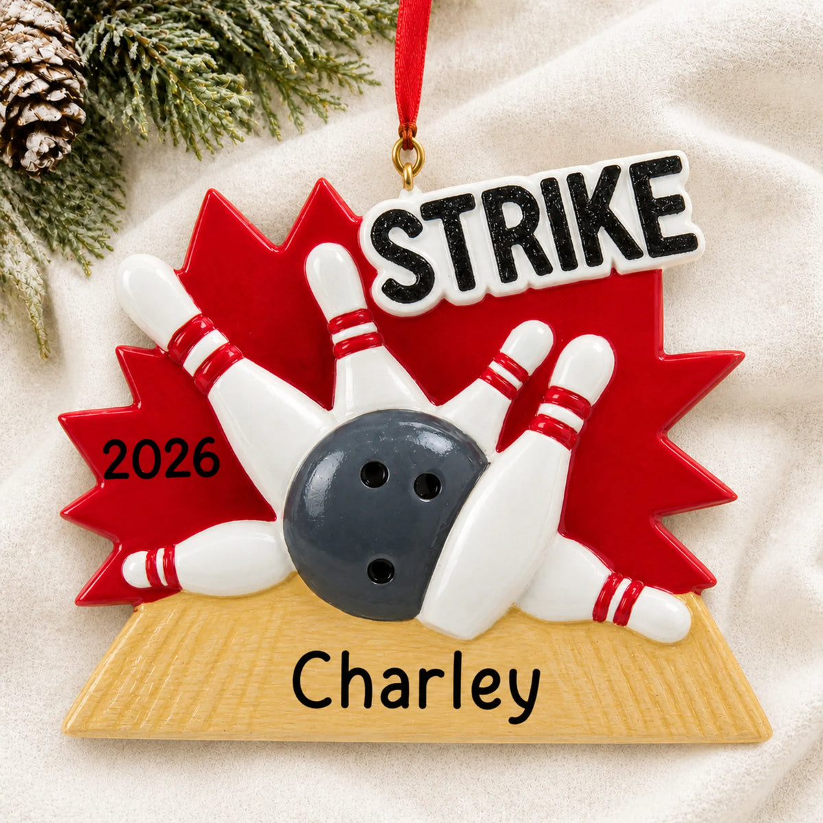 Personalized bowling strike christmas ornament laid on a soft white knit blanket