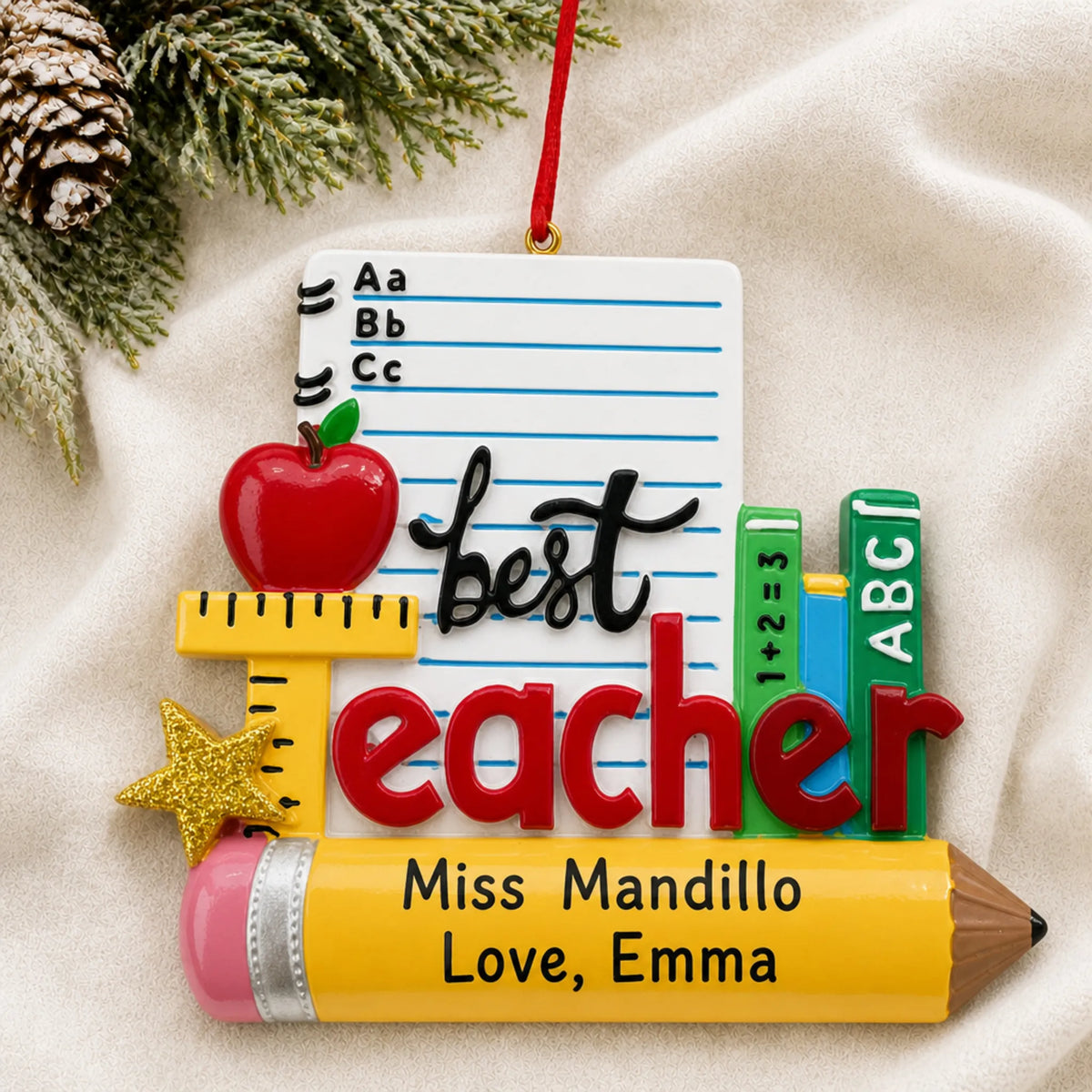 Personalized best teacher stationery Christmas ornament shown on a soft white blanket