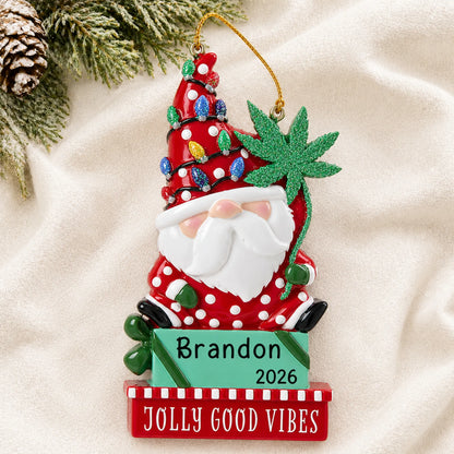 Personalized cannabis santa gnome christmas ornament laid on a soft white knit blanket