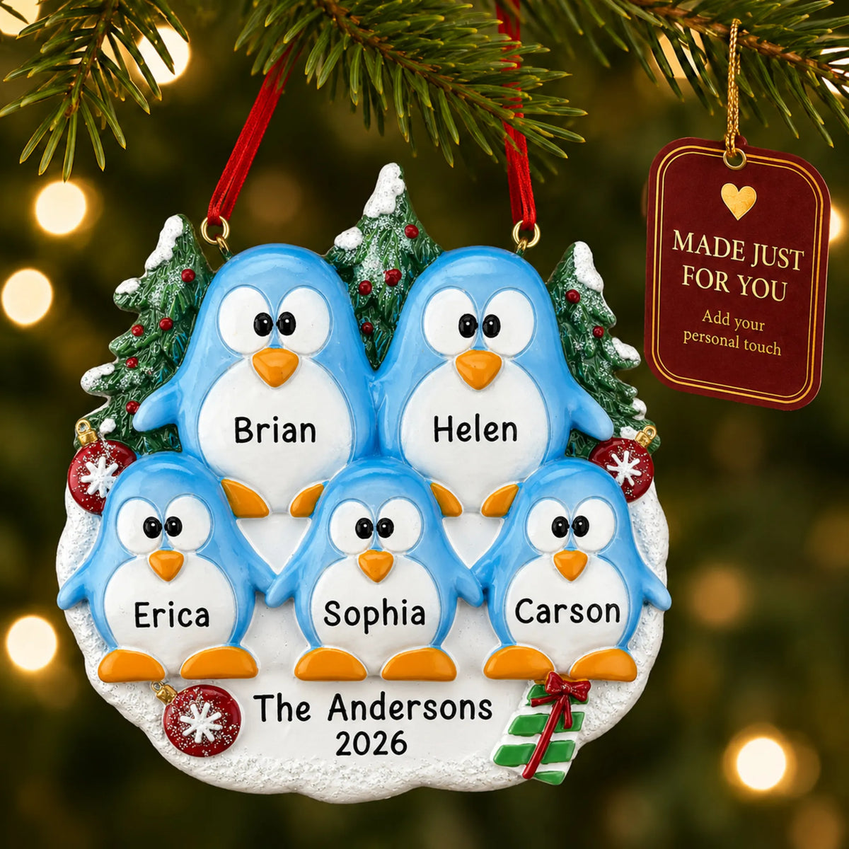 Penguin family of 5 christmas ornament hanging on a lit Christmas tree with a Made Just For You gift tag