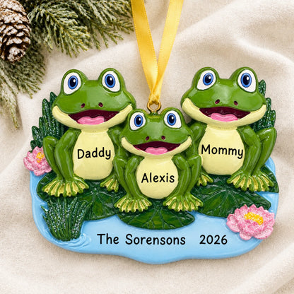 Personalized frog family of 3 christmas ornament laid on a soft white knit blanket