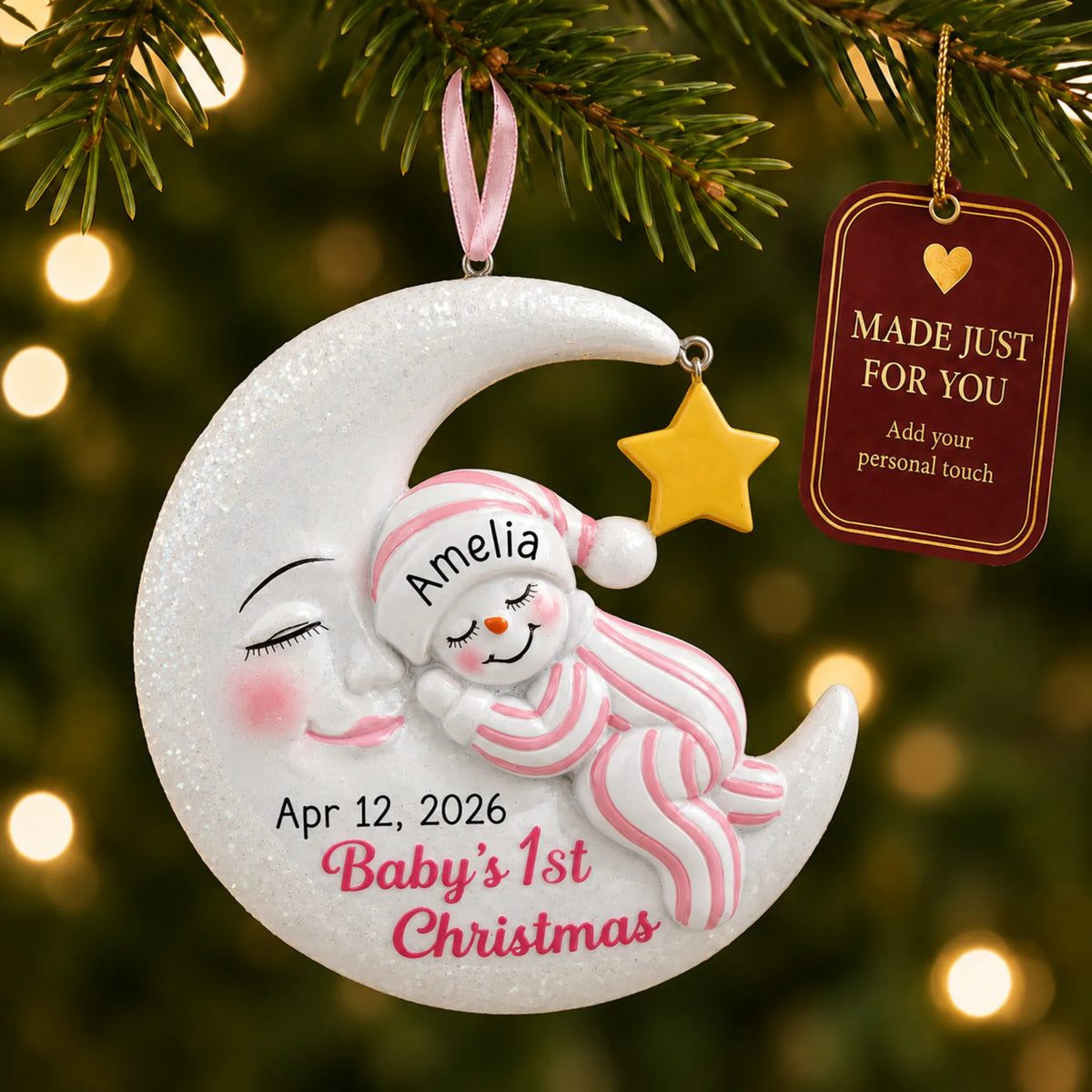Pink snowman baby's 1st christmas ornament hanging on a lit Christmas tree with a Made Just For You gift tag