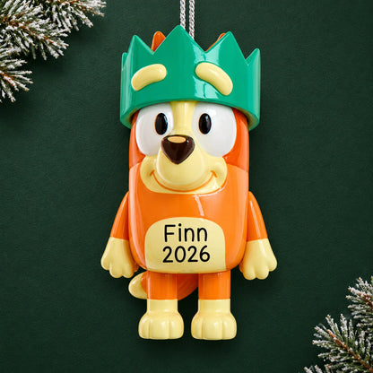 Personalized Bingo with crown Christmas ornament reading Finn 2026, shown on a dark green background with pine