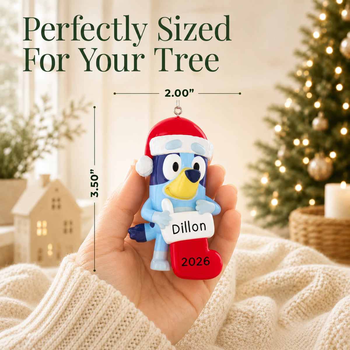 Size guide: the personalized Bluey Stocking christmas ornament shown in hand next to a Christmas tree