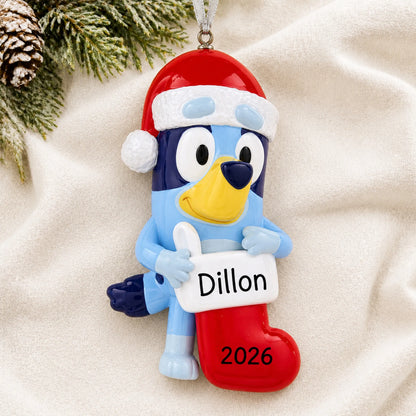 Personalized Bluey Stocking christmas ornament laid on a soft white knit blanket