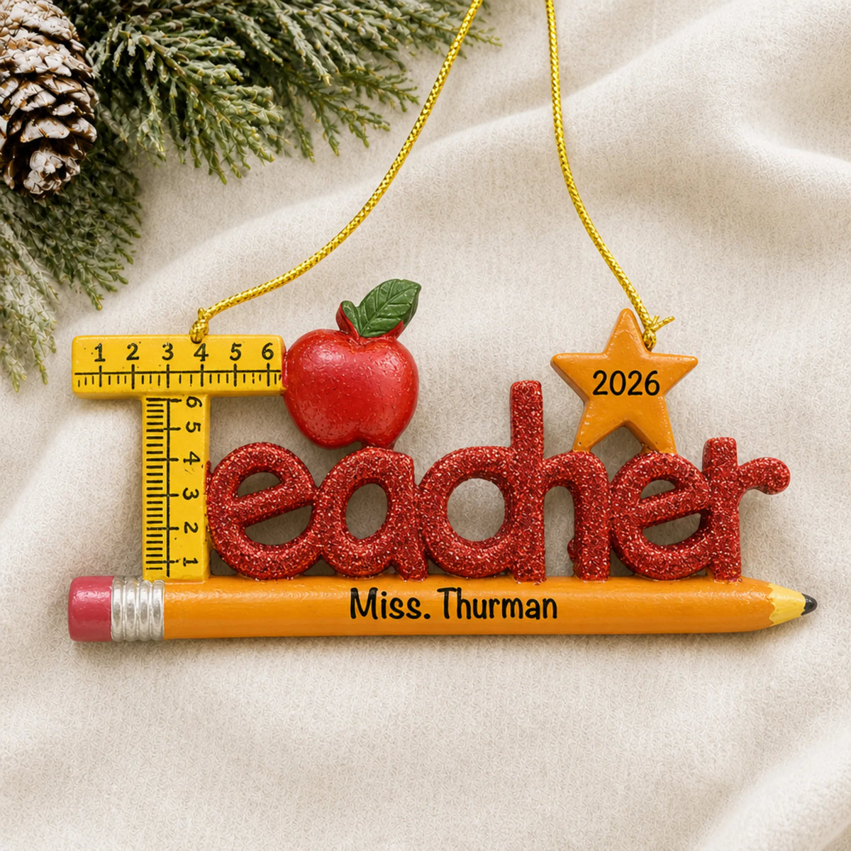 Personalized teacher's pencil Christmas ornament shown on a soft white blanket