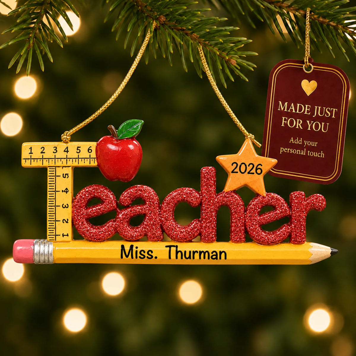 Personalized teacher's pencil Christmas ornament hanging among tree lights with a Made Just For You tag