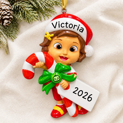 Personalized CoComelon Nina christmas ornament laid on a soft white knit blanket