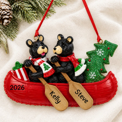 Personalized bear canoe couple christmas ornament laid on a soft white knit blanket
