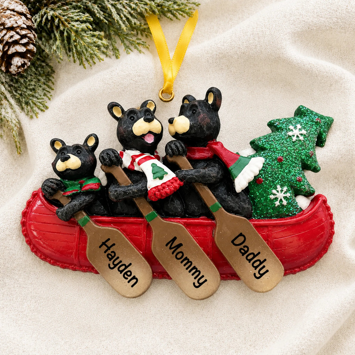 Personalized bear canoe family of 3 christmas ornament laid on a soft white knit blanket