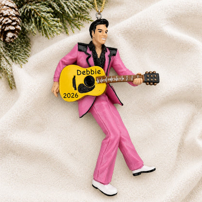 Personalized Elvis Presley guitar Christmas ornament reading Debbie 2026 on a white knit blanket with pine