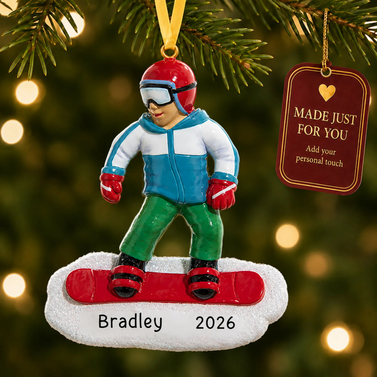 Snowboarding guy christmas ornament hanging on a lit Christmas tree with a Made Just For You gift tag