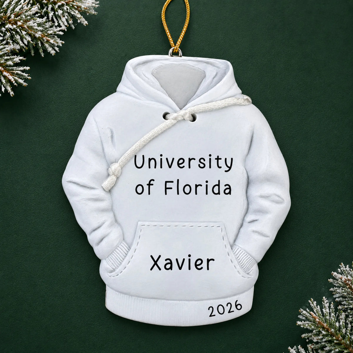 Personalized college hoodie Christmas ornament with name and year, shown on a green holiday background