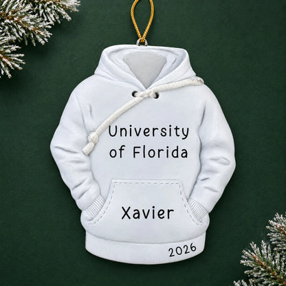Personalized college hoodie Christmas ornament with name and year, shown on a green holiday background