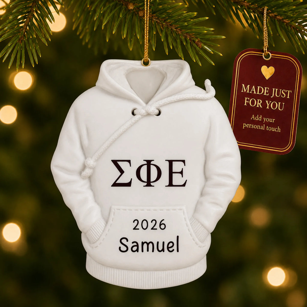 Personalized fraternity hoodie Christmas ornament hanging among tree lights with a Made Just For You tag