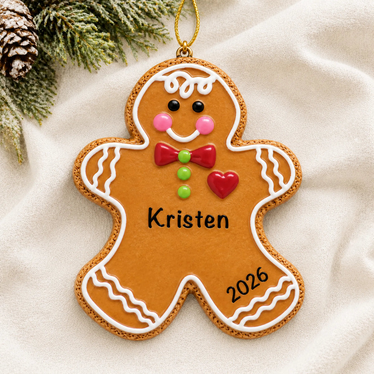 Personalized Gingerbread Man christmas ornament laid on a soft white knit blanket