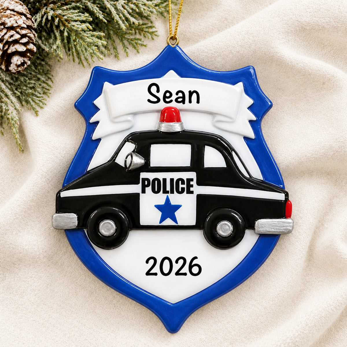 Personalized police badge emblem christmas ornament laid on a soft white knit blanket
