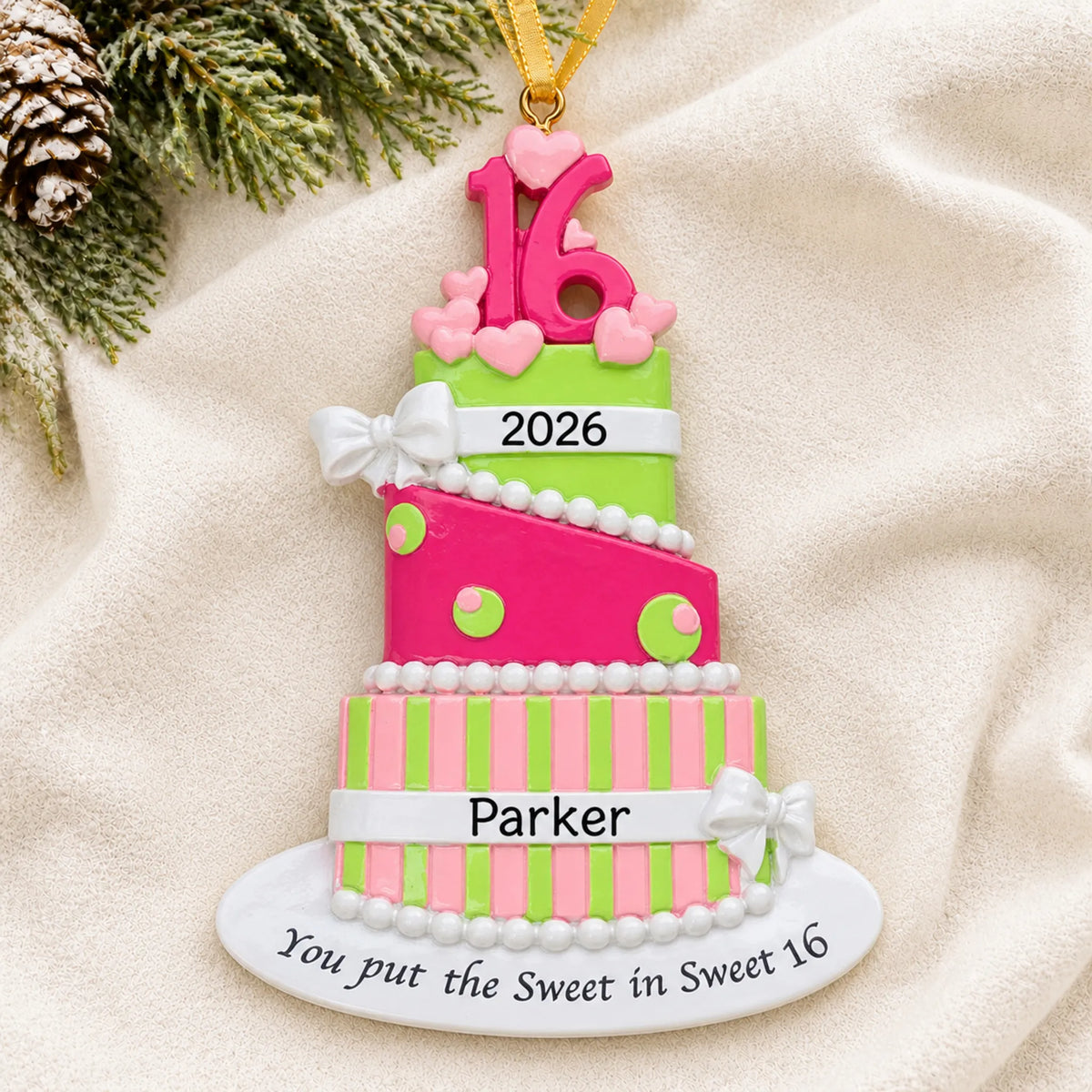 Personalized sweet 16 birthday cake christmas ornament laid on a soft white knit blanket
