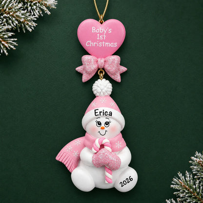 Personalized pink baby's 1st christmas candy cane snowbaby ornament on a dark green pine background