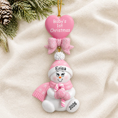 Personalized pink baby's 1st christmas candy cane snowbaby ornament laid on a soft white knit blanket