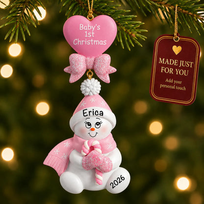 Pink baby's 1st christmas candy cane snowbaby ornament hanging on a lit Christmas tree with a Made Just For You gift tag