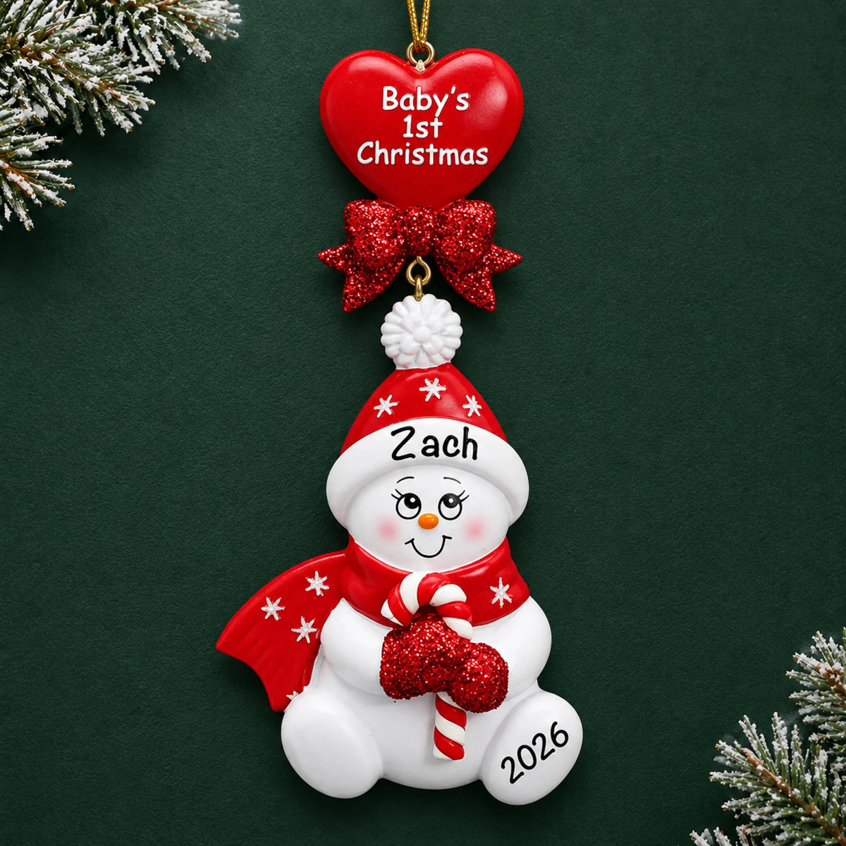 Personalized red baby's 1st christmas candy cane snowbaby ornament on a dark green pine background