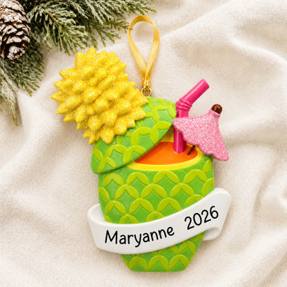 Personalized Pineapple Cocktail christmas ornament laid on a soft white knit blanket