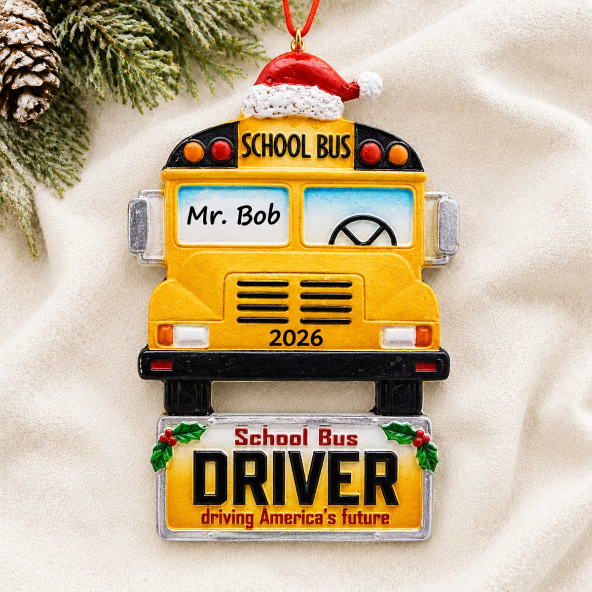 Personalized school bus driver Christmas ornament shown on a soft white blanket