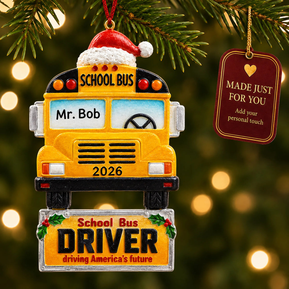 Personalized school bus driver Christmas ornament hanging among tree lights with a Made Just For You tag