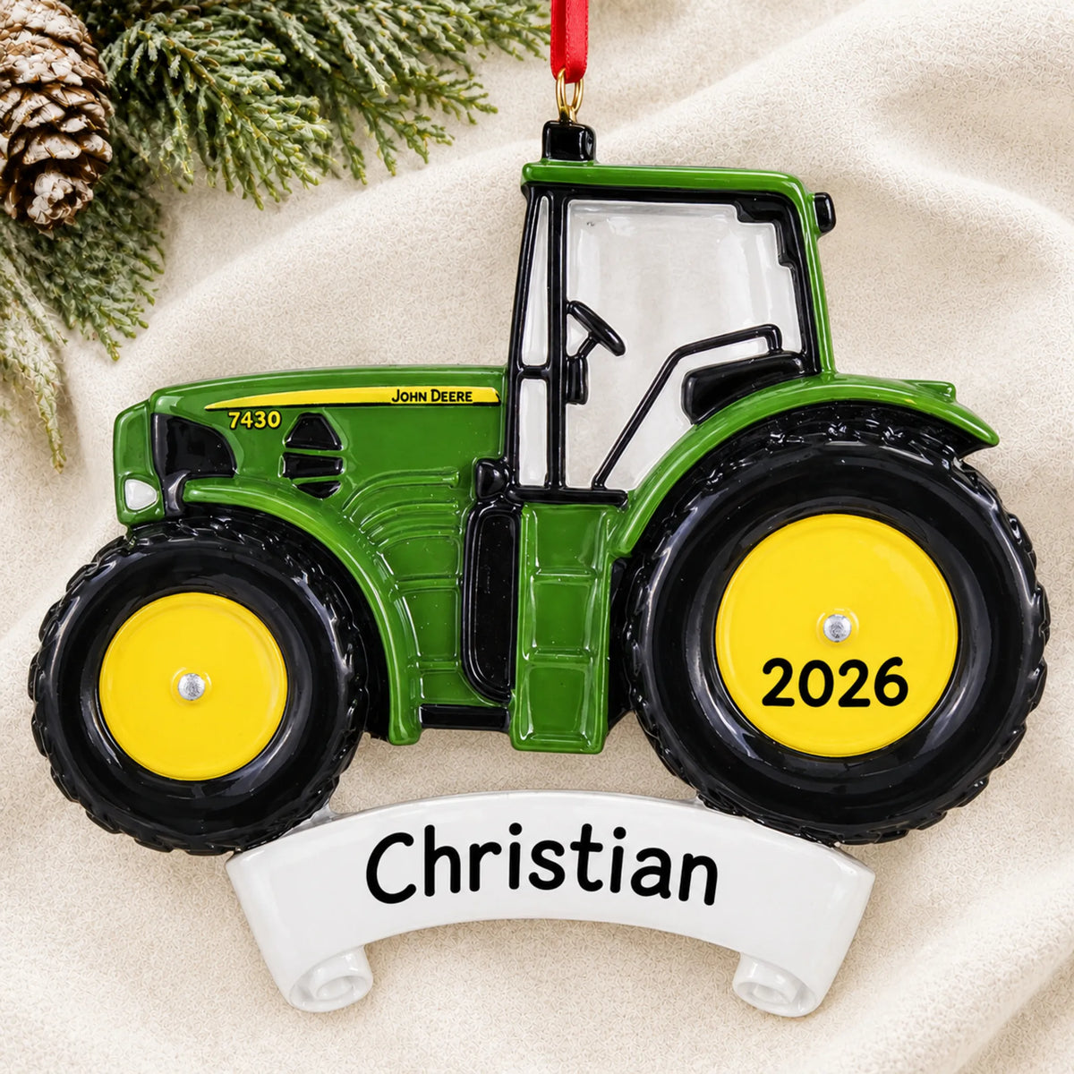 Personalized green farm tractor christmas ornament laid on a soft white knit blanket
