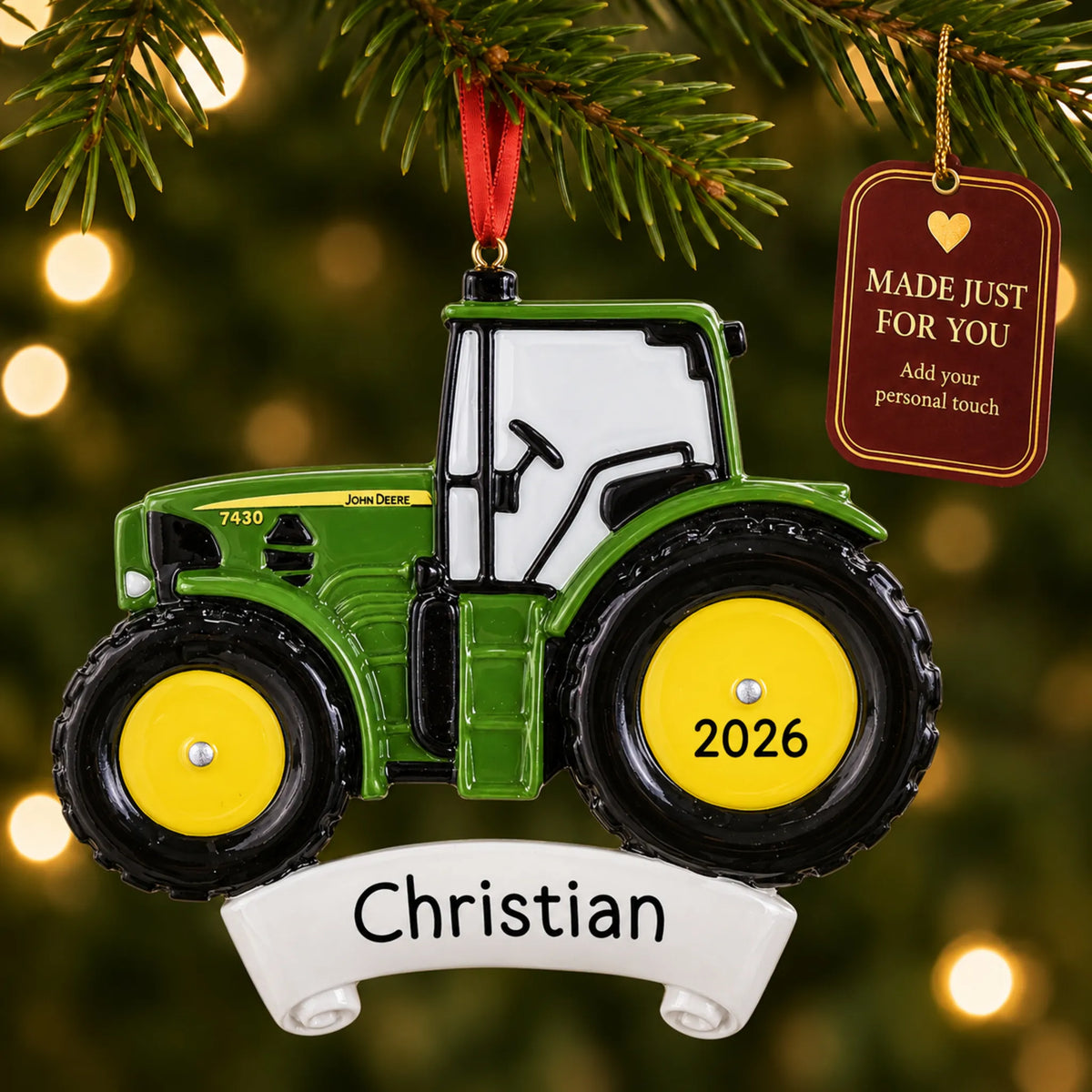 Green farm tractor christmas ornament hanging on a lit Christmas tree with a Made Just For You gift tag