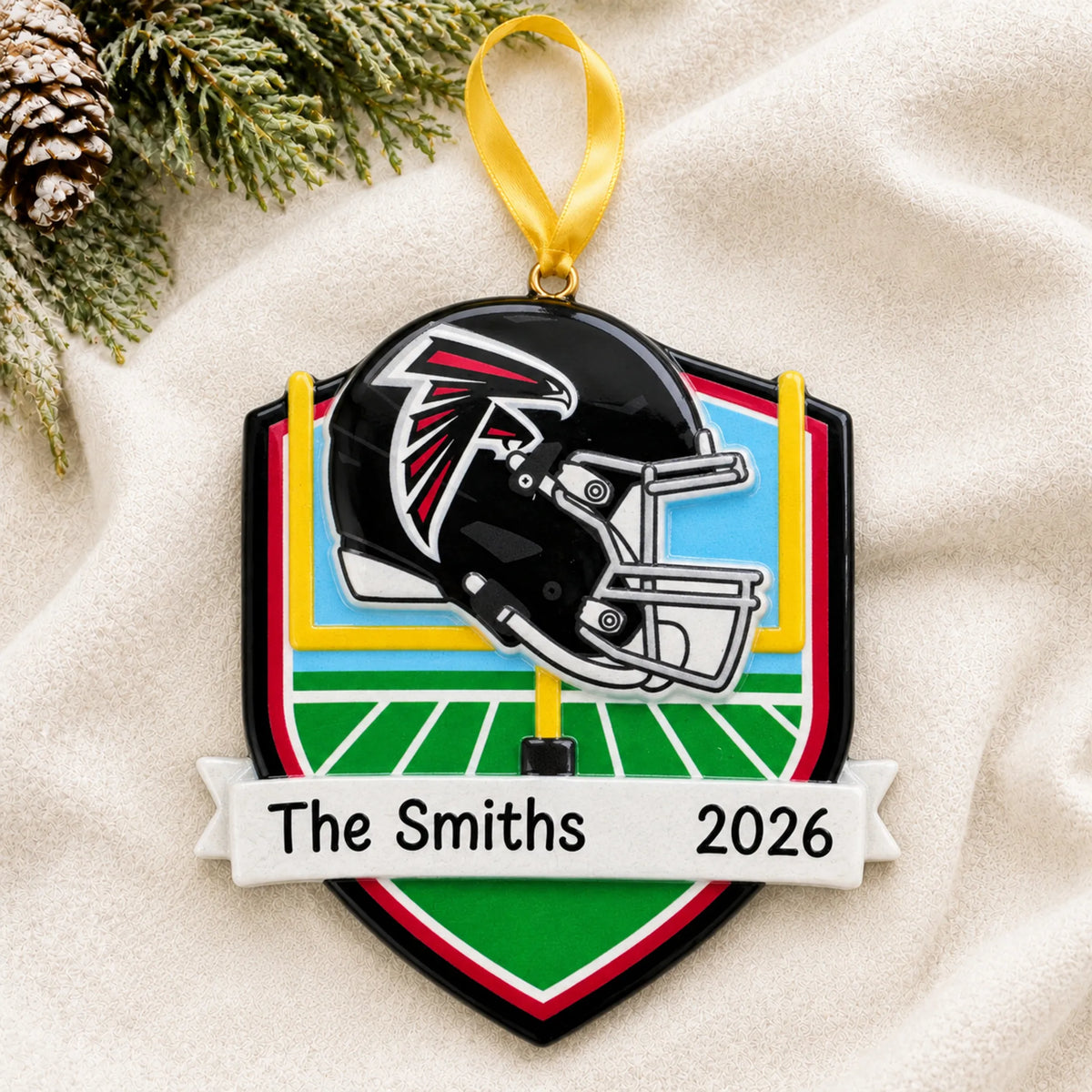 Personalized Atlanta Falcons NFL christmas ornament laid on a soft white knit blanket