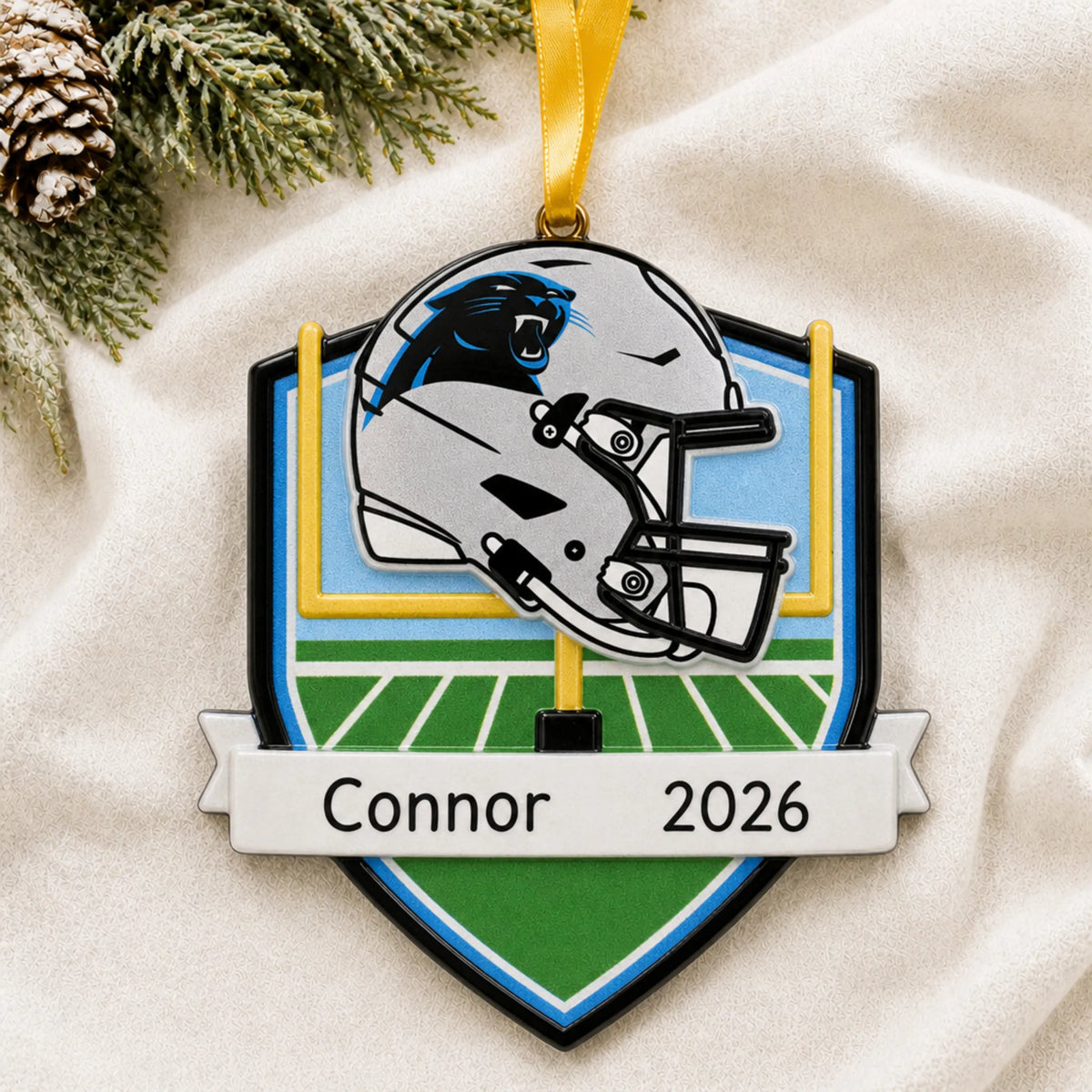 Personalized Carolina Panthers NFL christmas ornament laid on a soft white knit blanket