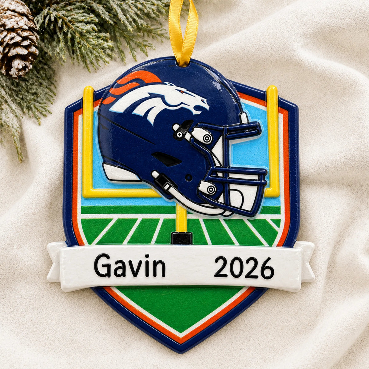 Personalized Denver Broncos NFL christmas ornament laid on a soft white knit blanket