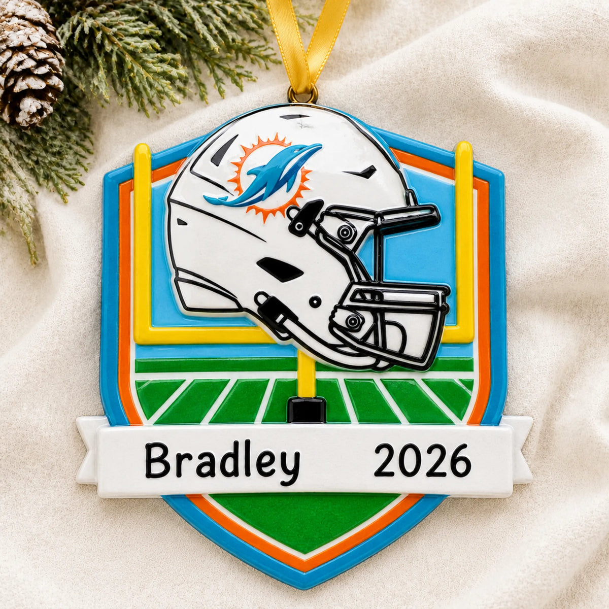 Personalized Miami Dolphins NFL christmas ornament laid on a soft white knit blanket