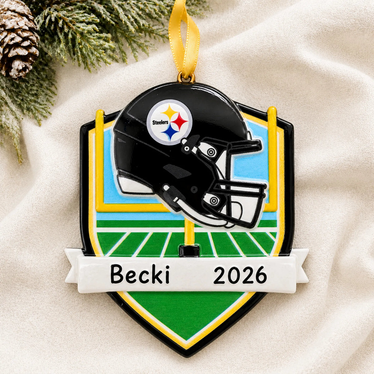 Personalized Pittsburgh Steelers NFL christmas ornament laid on a soft white knit blanket