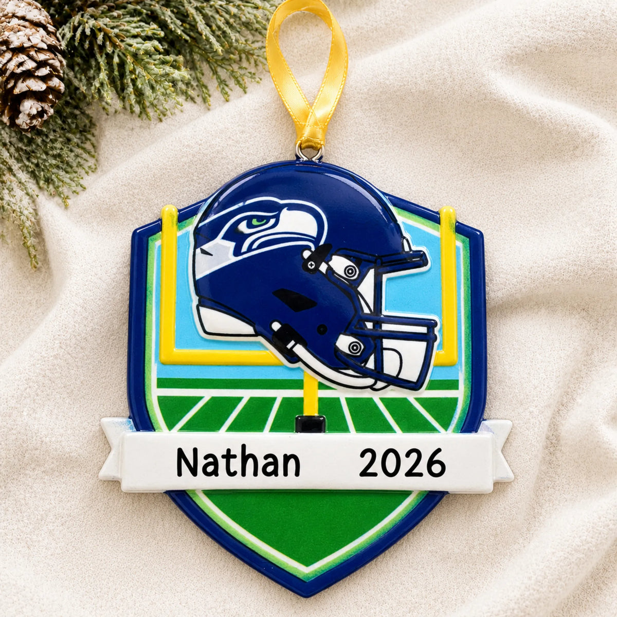 Personalized Seattle Seahawks NFL christmas ornament laid on a soft white knit blanket