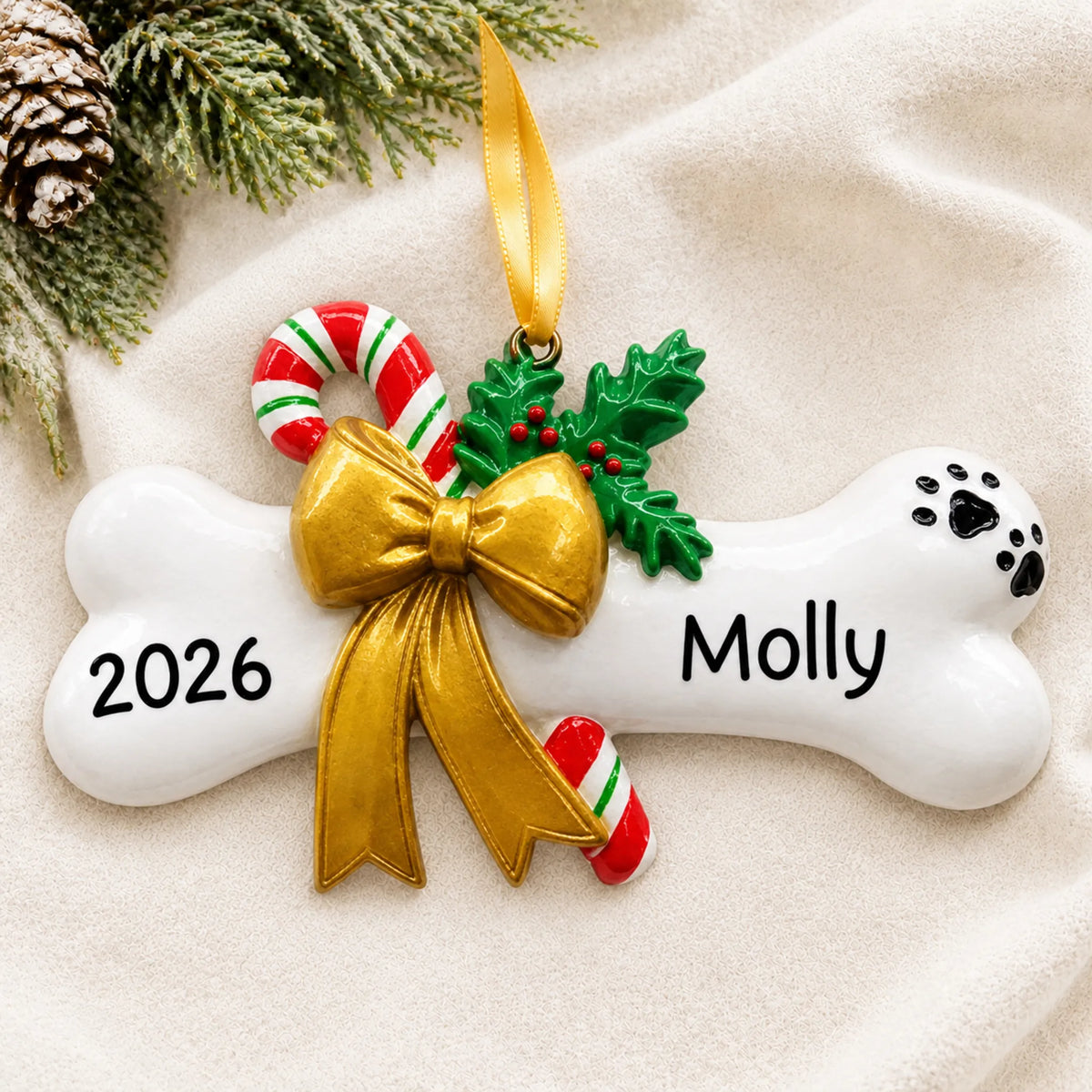 Personalized Dog Bone with Holly christmas ornament laid on a soft white knit blanket