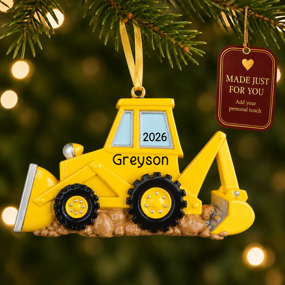Backhoe christmas ornament hanging on a lit Christmas tree with a Made Just For You gift tag